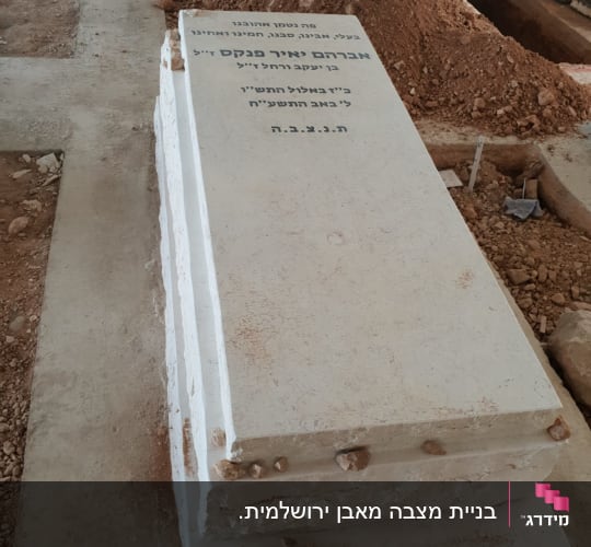מצבת אבן טבעית בהירה עם כיתוב חרוט בבית עלמין